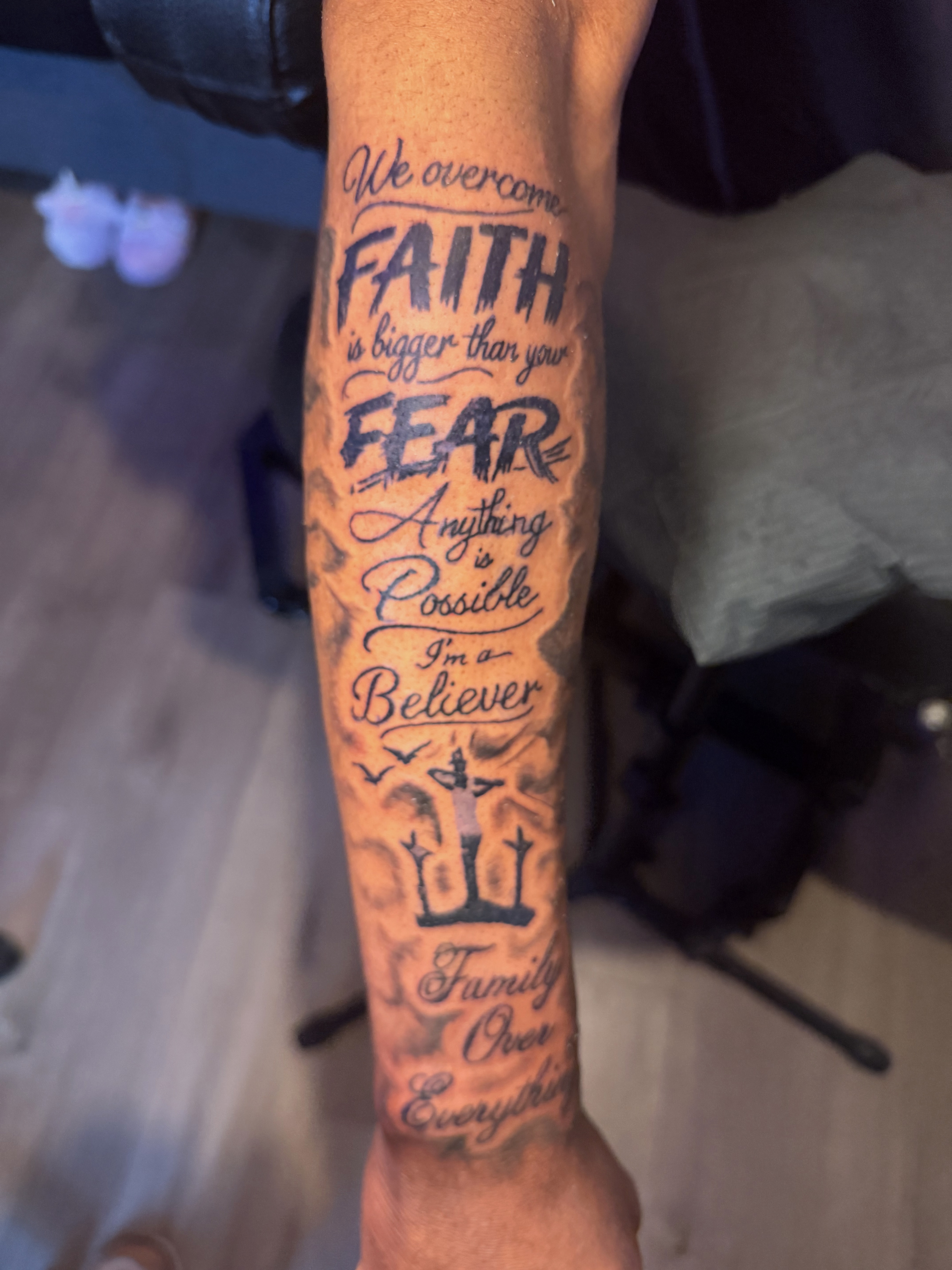 Vertical script lettering forearm tattoo